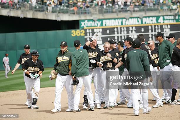 Ryan Sweeney of the Oakland Athletics is mobbed by his teammates after his game winning walk-off hit after the game against the Baltimore Orioles at...