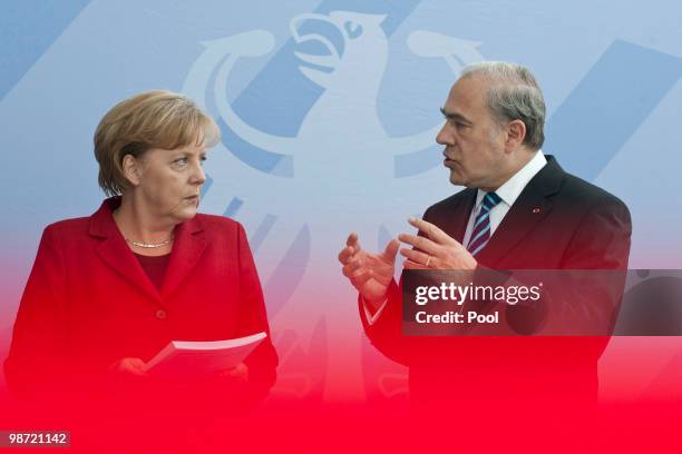 German Chancellor Angela Merkel talks to OECD Secretary-General Jose Angel Gurria during the handover of the OECD Report at the Chancellery on April...