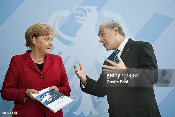 German Chancellor Angela Merkel talks to OECD Secretary-General Jose Angel Gurria during the handover of the OECD Report at the Chancellery on April...