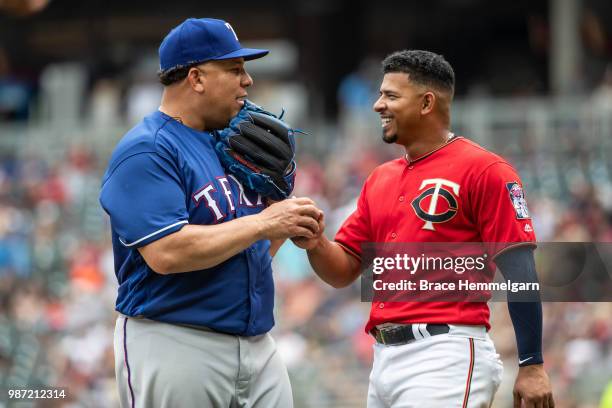 Bartolo Colon of the Texas Rangers talks with Eduardo Escobar of the Minnesota Twins on June 24, 2018 at Target Field in Minneapolis, Minnesota. The...
