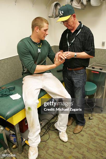 Ryan Sweeney of the Oakland Athletics has his hand checked out by Dr. John Frazier in the clubhouse after the game against the Baltimore Orioles at...