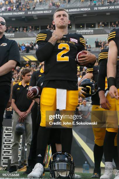 Johnny Manziel of the Hamilton Tiger-Cats during the anthem of a pre-season game against the Toronto Argonauts at Tim Hortons Field on June 1, 2018...