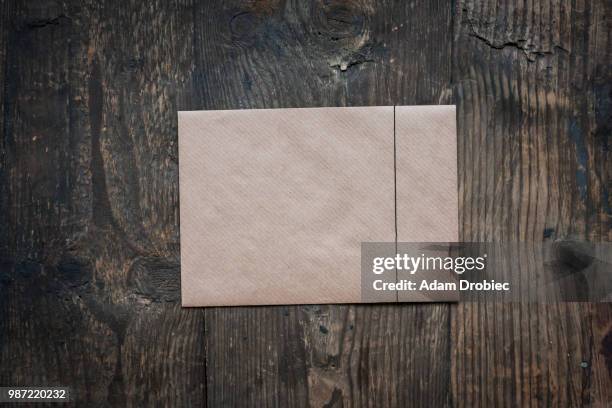 brown envelope on wooden background - brown envelope stock pictures, royalty-free photos & images