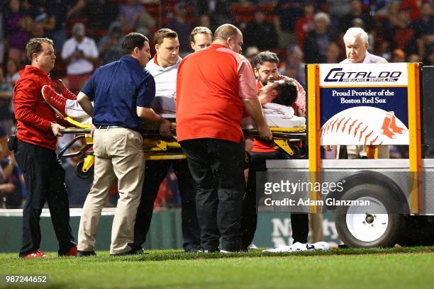 Jake Jewell of the Los Angeles Angels is carted off the field after he injured his right ankle when he slid into home plate in a failed attempt to...