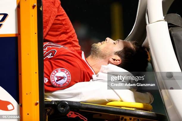 Jake Jewell of the Los Angeles Angels is carted off the field after he injured his right ankle when he slid into home plate in a failed attempt to...