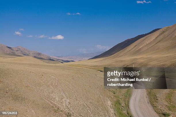 country road leading into wilderness, near song kol, kyrgyzstan, central asia - kol stock pictures, royalty-free photos & images