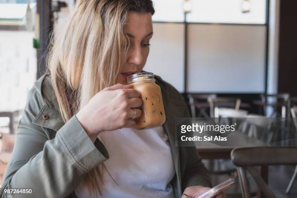 beautiful woman drinking iced coffee - alas stock-fotos und bilder