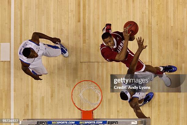 Mikhail Torrance of the Alabama Crimson Tide drives for a shot attempt against DeMarcus Cousins of the Kentucky Wildcats during the quarterfinals of...