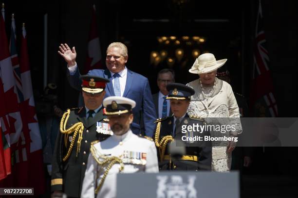 Doug Ford, Ontario's premier, left, waves while walking with Elizabeth Dowdeswell, Ontario's lieutenant governor, on the front steps of Queens Park...