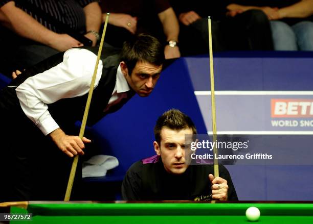 Ronnie O'Sullivan of England and Mark Selby of England show interest as Referee Leo Scullion replaces the balls after a foul shot, during their...