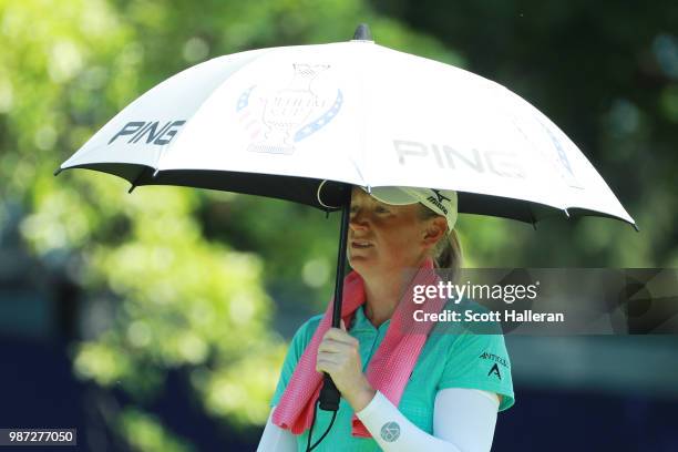 Stacy Lewis walks under an umbrella off the tenth tee during the second round of the KPMG Women's PGA Championship at Kemper Lakes Golf Club on June...