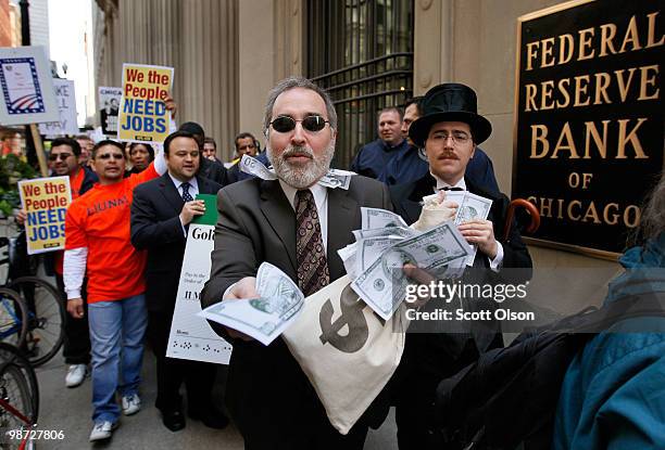 Richard Shavzin , a member of the Screen Actors Guild pretends to hand out fake money as he marches through the financial district along with...