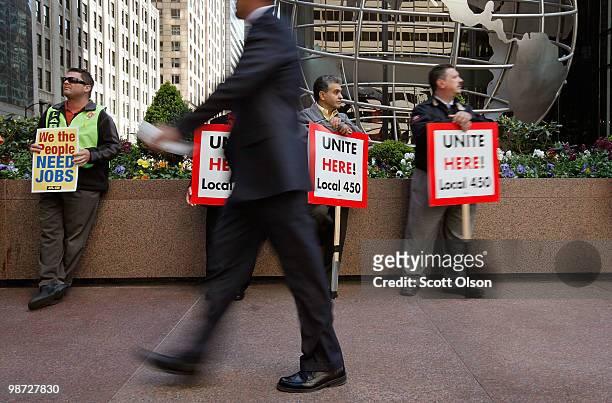 Pedestrian passes union workers gathering outside Willis Tower before a march through the financial district calling for job creation and financial...