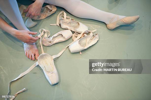 Student of Christa Charmolu, puts on her ballet shoes on April 06, 2010 at the Paris National Conservatory of Sound, music and Dance . Repetto was...