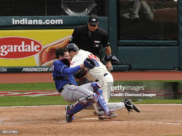 Catcher Taylor Teagarden of the Texas Rangers tags out designated hitter Travis Hafner of the Cleveland Indians on a play at the plate as homeplate...