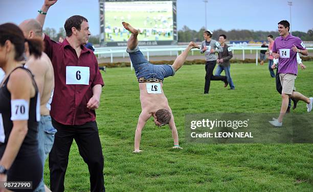 Competitor crosses the finish line in style at the end of the "People's Cup" race at Kempton Park race track at Sunbury on Thames in Middlesex on...