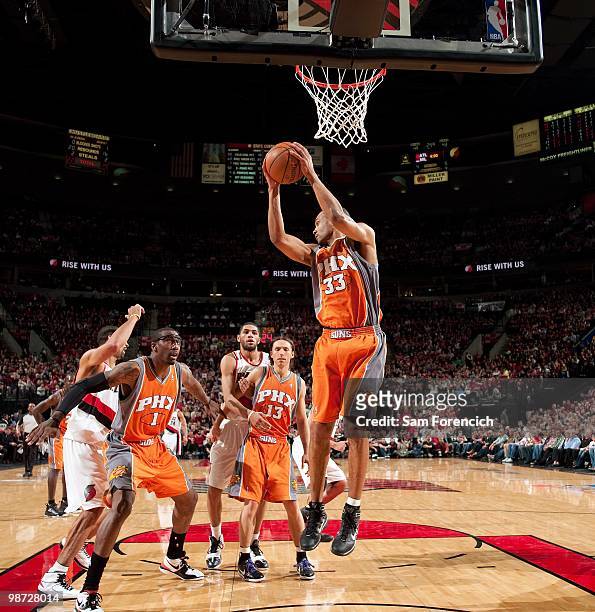 Grant Hill of the Phoenix Suns rebounds as teammates Amar'e Stoudemire and Steve Nash box out Juwan Howard and Nicolas Batum of the Portland Trail...