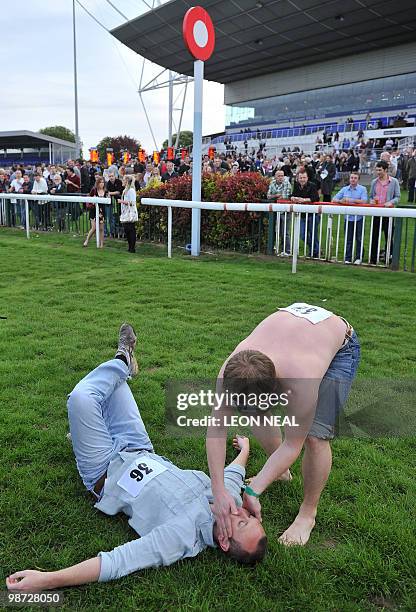 Competitor lays on his back at the finish line of the "People's Cup" race at Kempton Park race track at Sunbury on Thames in Middlesex on April 28,...