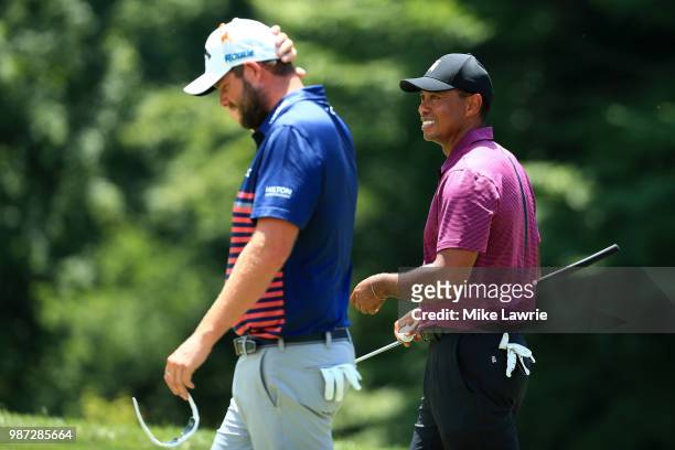 Marc Leishman of Australia and Tiger Woods react after their round on the ninth green during the second round of the Quicken Loans National at TPC...