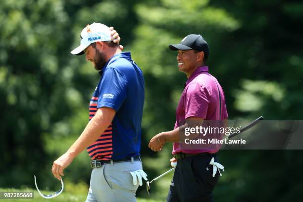 Marc Leishman of Australia and Tiger Woods react after their round on the ninth green during the second round of the Quicken Loans National at TPC...