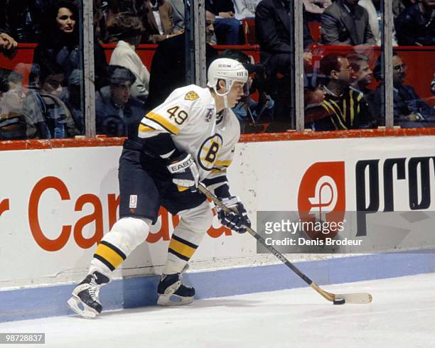 Joe Juneau of the Boston Bruins skates with the puck against the Montreal Canadiens in the early 1990's at the Montreal Forum in Montreal, Quebec,...