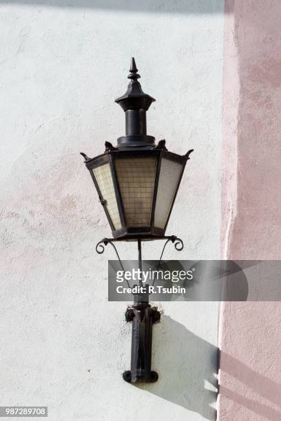 old lantern on wall in street of tallin old town, estonia - town wall tallinn stock pictures, royalty-free photos & images