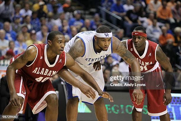 DeMarcus Cousins of the Kentucky Wildcats gets set to fight for rebound position on a free throw attempt against Justin Knox and Senario Hillman of...