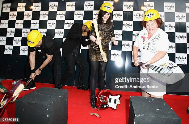 Singer Amy Macdonald smashes a guitar beside Rita Gilligan at the Hard Rock Cafe Berlin re-opening on April 28, 2010 in Berlin, Germany.