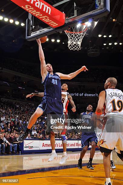 Kosta Koufos of the Utah Jazz goes to the hoop past past Monta Ellis of the Golden State Warriors at Oracle Arena on April 13, 2010 in Oakland,...