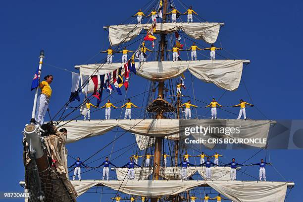 Cadets stand on the Colombian Navy sailboat Gloria rigging as they approach their mooring place at the Callao Naval Base in Peru, on April 28, 2010....