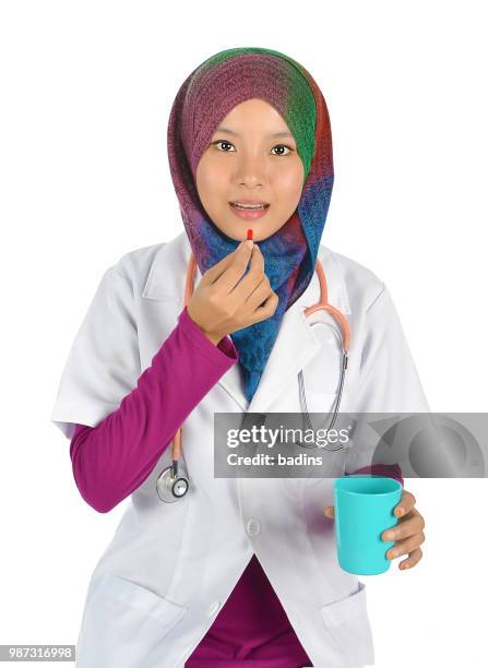 portrait of a beautiful muslim woman holding a white paper with smile, isolated on white background - nurse and portrait and white background and smiling and female and looking at camera stock pictures, royalty-free photos & images