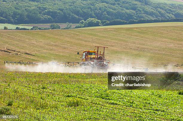 botas de pulverización de aerosol de tractor con el fertilizante en campo - fertilizante fotografías e imágenes de stock