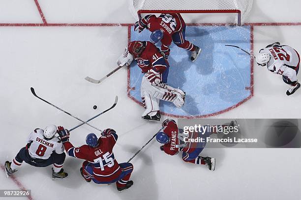 Hal Gill of Montreal Canadiens and Alex Ovechkin of the Washington Capitals battles for a loose puck in front of Jaroslav Halak of Montreal Canadiens...