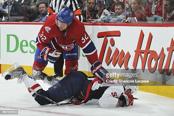 Mike Green of the Washington Capitals falls on Travis Moen of Montreal Canadiens sticks in Game Six of the Eastern Conference Quarterfinals during...