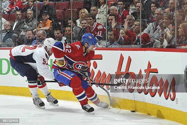 Dominic Moore of the Montreal Canadiens battles for the puck with Mike Green of the Washington Capitals in Game Six of the Eastern Conference...