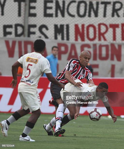 Alex Silva of Brazil's Sao Paulo vies for the ball with Victor Piriz of Peru's Universitario de Deportes during their match as part of 2010...