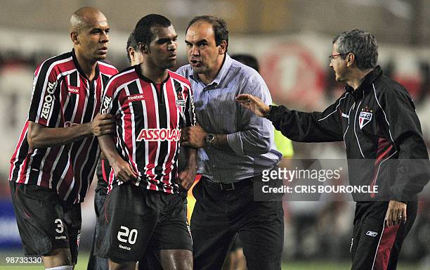 Brazilian player Richarylson of Sao Paulo is escorted out of the pitch by teammate Alex Silva and staff members after he was expelled folloowing a...