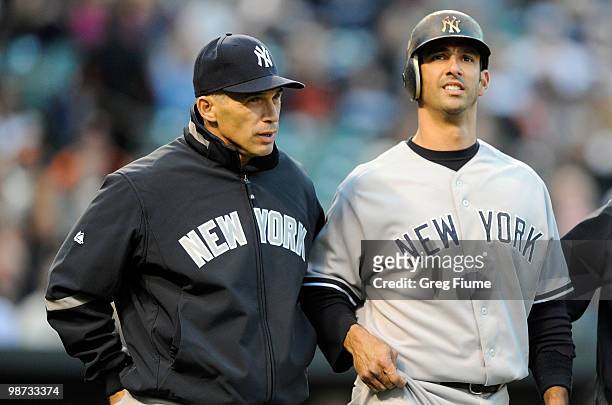 Manager Joe Girardi of the New York Yankees checks on Jorge Posada after he was hit with a pitch during the game against the Baltimore Orioles at...
