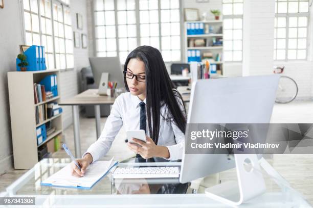 aziatische jonge vrouw schrijven en het gebruik van slimme telefoon - mobile phone edit stockfoto's en -beelden