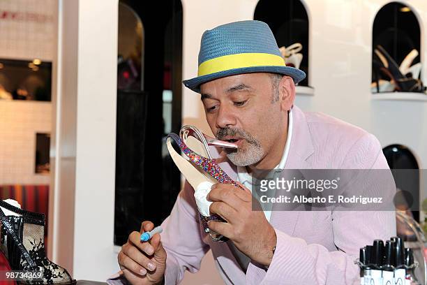 Designer Christian Louboutin signs an autograph at the grand opening of the new Christian Louboutin boutique on April 28, 2010 in West Hollywood,...