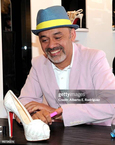 Designer Christian Louboutin signs an autograph at the grand opening of the new Christian Louboutin boutique on April 28, 2010 in West Hollywood,...