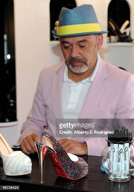 Designer Christian Louboutin signs an autograph at the grand opening of the new Christian Louboutin boutique on April 28, 2010 in West Hollywood,...