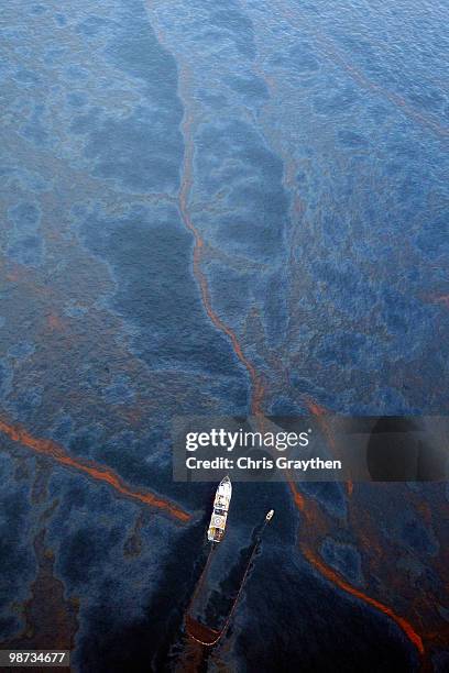 Boat works to collect oil that has leaked from the Deepwater Horizon wellhead in the Gulf of Mexico on April 28, 2010 near New Orleans, Louisiana. An...