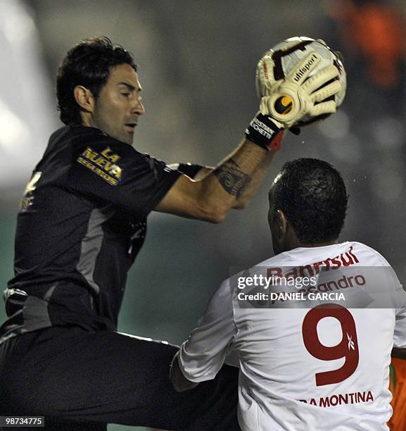 Argentina's Banfield goalkeeper Cristian Lucchetti catches the ball over forward Alecsandro of Brazilian Internacional during their round before the...