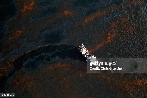 Boat makes its way through crude oil that has leaked from the Deepwater Horizon wellhead in the Gulf of Mexico on April 28, 2010 near New Orleans,...