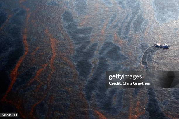 Boat makes its way through crude oil that has leaked from the Deepwater Horizon wellhead in the Gulf of Mexico on April 28, 2010 near New Orleans,...