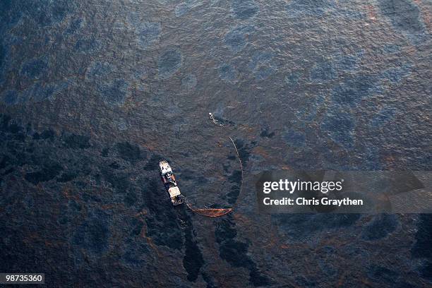 Boat works to collect oil that has leaked from the Deepwater Horizon wellhead in the Gulf of Mexico on April 28, 2010 near New Orleans, Louisiana. An...