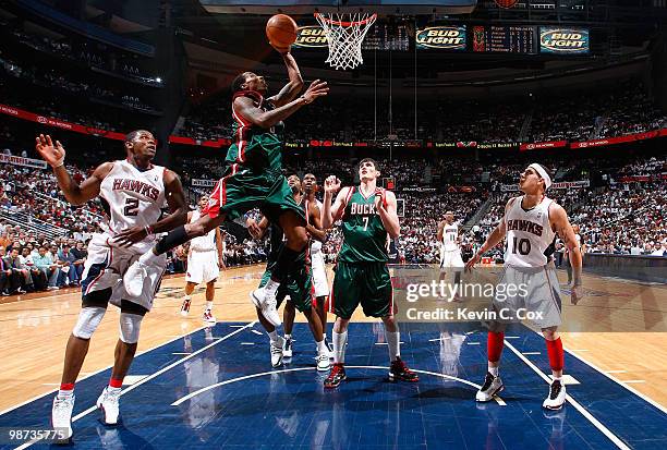 Brandon Jennings of the Milwaukee Bucks lays in a basket against Joe Johnson and Mike Bibby of the Atlanta Hawks during Game Five of the Eastern...