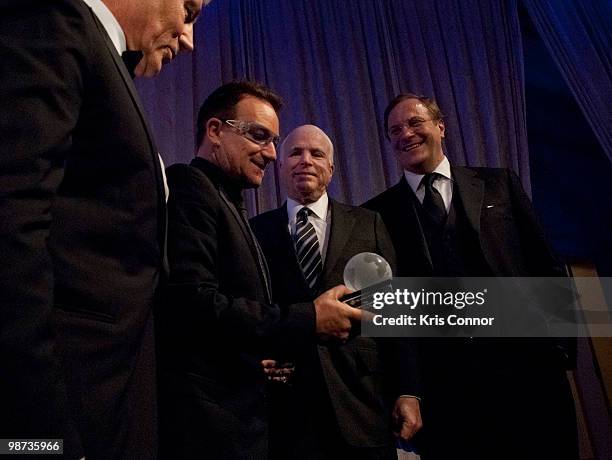 Former U.S. Sen. Chuck Hagel, U2 frontman Bono and Sen. John McCain pose for a photo as Bono is awarded the Distinguished Humanitarian Leadership...