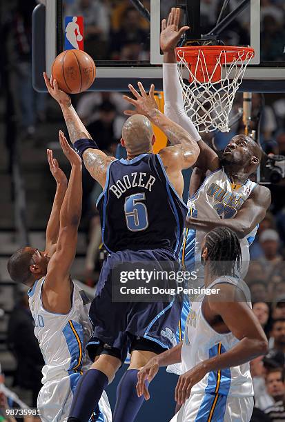 Carlos Boozer of the Utah Jazz puts up a shot against the defense of Arron Afflalo, Johan Petro and Nene of the Denver Nuggets in Game Five of the...